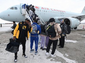 Receiver Rasheed Bailey (left) grabs some footage as he and the rest of the Winnipeg Blue Bombers board a plane at Winnipeg International Airport on Tuesday, Dec. 7, 2021, en route to the 108th Grey Cup against the Tiger-Cats in Hamilton on Sunday.