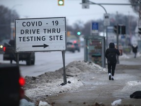 A person walks past a sign for a Covid-19 testing site in Winnipeg on Wednesday Dec. 15. Chris Procaylo/Winnipeg Sun