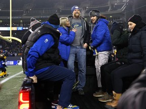 Head coach Mike O’Shea (top middle) loads onto the back of a truck as the Winnipeg Blue Bombers celebrated its 2021 Grey Cup win at IG Field on Wed., Dec. 15, 2021.  KEVIN KING/Winnipeg Sun/Postmedia Network