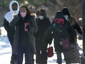 A group of people wear masks while crossing a street in Winnipeg.   Chris Procaylo,  Tuesday Dec. 21. 2021 Winnipeg Sun