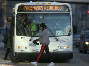 A person walks in front of a bus in Winnipeg on Tuesday afternoon. Chris Procaylo/Winnipeg Sun