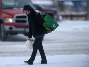 A person carries grocery items along a sidewalk in Winnipeg on Thursday, Dec. 23. 2021.