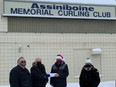 (Left to right) Assiniboine Memorial Curling Club's Bruce Wilkinson, Al Seredynski and (far right) current club manager Jody Smart present a cheque for $534.50 to Winnipeg Sun's Glen Dawkins for the Empty Stocking Fund and the Christmas Cheer Board at the Assiniboine Memorial Curling Club in Winnipeg on Tuesday, Dec. 28, 2021.