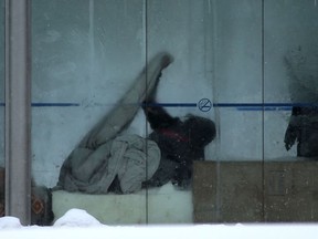 A person adjusts a blanket while in a bus shack in Winnipeg on Tuesday.  Chris Procaylo/Winnipeg Sun