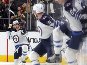 Kyle Connor of the Winnipeg Jets celebrates after scoring a goal in overtime against the Vegas Golden Knights to win their game 5-4 as teammates jump the boards to join him at T-Mobile Arena on Jan. 2, 2022 in Las Vegas.