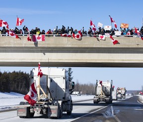 Supporters of truckers protesting the Canadian government’s vaccine mandate for cross-border truckers gather on the Dilworth Road Highway 416 overpass as the convoy makes its way to Ottawa on Friday, Jan. 28, 2022.