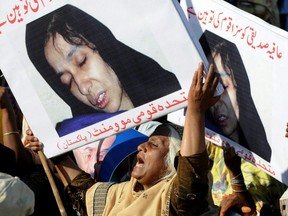 Supporters of Pakistani political party Muttahida Qaumi Movement hold photographs of Aafia Siddiqui as they shout slogans during a protest rally in Karachi, Sept. 28, 2010 to condemn the verdict against Pakistani scientist Aafia Siddiqui.