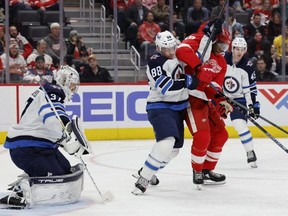 Winnipeg Jets defenceman Nate Schmidt and Detroit Red Wings right wing Givani Smith battle for the puck in front of goaltender Connor Hellebuyck at Little Caesars Arena Thursday. USA TODAY Sports