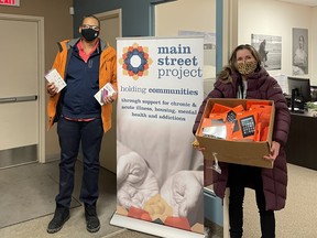 Matthew Tate, Founder and CEO of Winnipeg tech company Upfeat (left) presents Main Street Project’s Director of Development Anastasia Ziprick (right) with a donation of tablets for the organization to use at its COVID isolation accommodation and in its two withdrawal management services.