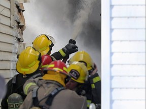 Firefighters battle a blaze in a multi-family dwelling on McKenzie Street near Stella Avenue in Winnipeg on Sunday, Jan. 2, 2022.