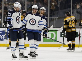 Winnipeg Jets right wing Blake Wheeler (26), center Andrew Copp (9) and left wing Kyle Connor (81) head for the locker room after their 3-2 loss to the Boston Bruins at TD Garden in Boston on Jan. 22, 2022.