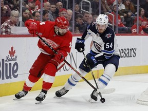 Detroit Red Wings center Robby Fabbri (14) and Winnipeg Jets defensceman Dylan Samberg (54) battle for the puck in the second period at Little Caesars Arena. Mandatory Credit: Rick Osentoski-USA TODAY Sports