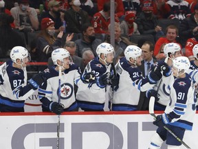 Winnipeg Jets center Cole Perfetti (91) celebrates with teammates after scoring his first career NHL goal against the Washington Capitals in the first period at Capital One Arena in Washington, DC on January 18, 2022.