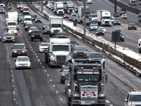 A tractor-trailer with a 'Freedom Convoy" sign makes their way eastbound on the 401, at the Don Mills Rd. overpass in Toronto, Ont. on Thursday January 27, 2022.