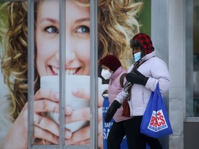 Two people wear masks while out running errands in Winnipeg on Wednesday. Chris Procaylo/Winnipeg Sun