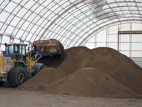 A tractor manages a dwindling pile of road sand at the city's public works east yard on Thomas Avenue in Winnipeg on Tuesday, Jan. 11, 2022.