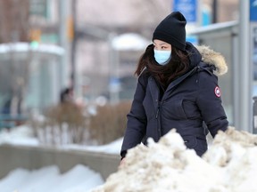 A woman wearing a mask walks in downtown Winnipeg on Tuesday, Jan. 11, 2022.
