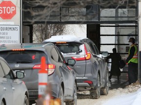 Vehicles enter the drive-through COVID-19 testing site on Main Street in Winnipeg on Monday, Jan. 17, 2022.