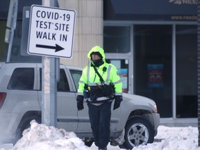 A person walks past a sign for a COVID-19 test site in Winnipeg on Wednesday. Chris Procaylo/Winnipeg Sun.