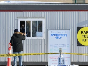 A man shows his information to pick up COVID-19 rapid testing kits in a parking lot on Taylor Avenue in Winnipeg on Wed., Jan. 19, 2022.  KEVIN KING/Winnipeg Sun/Postmedia Network