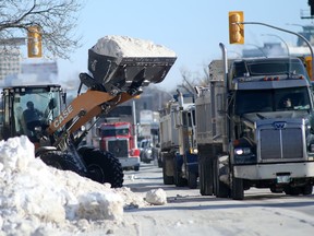 The City of Winnipeg is in the process of removing snow piles along roads. These crews were working on Portage Avenue Tuesday afternoon. On Tuesday evening a front-end loader was involved in a fatal crash on the Disraeli Freeway bridge. Chris Procaylo/Winnipeg Sun