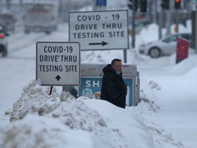 A person walks near signs for a Covid-19 testing site in Winnipeg on Wednesday. Chris Procaylo/Winnipeg Sun.