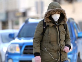 A person wearing a mask walks in downtown Winnipeg on Tuesday, Jan. 25, 2022.