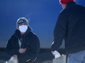 Two people wear masks while speaking to each other in Winnipeg on Thursday, Jan. 27, 2022.