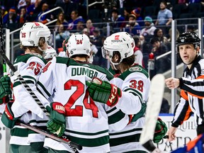 Kirill Kaprizov (#97) of the Minnesota Wild is congratulated by his teammates after scoring a goal against the New York Islanders.