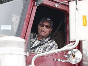 An angry American trucker speaks to people as they block highway 75 with heavy trucks and farm equipment and access to the Canada/US border crossing at Emerson, Man., Thursday, Feb. 10, 2022. The blockade was set up to rally against provincial and federal COVID-19 vaccine mandates and in support of Ottawa protestors. THE CANADIAN PRESS/John Woods