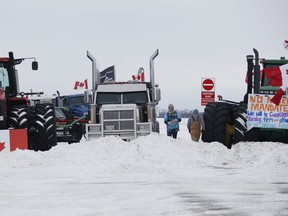 People block highway 75 with heavy trucks and farm equipment and access to the Canada/US border crossing at Emerson, Man., Thursday, Feb. 10, 2022. The blockade was set up to rally against provincial and federal COVID-19 vaccine mandates and in support of Ottawa protestors. THE CANADIAN PRESS/John Woods