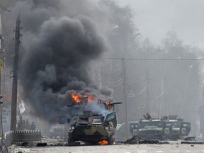 This photograph taken on Feb. 27, 2022 shows a Russian Armoured personnel carrier (APC) burning during fight with the Ukrainian armed forces in Kharkiv.