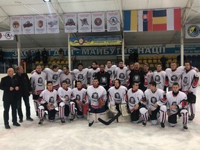 Former NHLers Wayne Babych (black jersey, centre) and brother Dave Babych (black jersey, right) with teenagers in Ukraine.