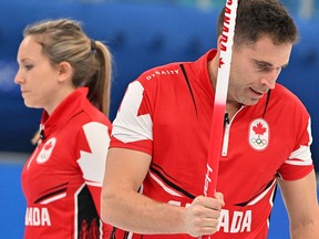 Canada's John Morris and Canada's Rachel Homan (L) react after the mixed doubles round robin session 13 game of the Beijing 2022 Winter Olympic Games curling competition between Canada and Italy, at the National Aquatics Centre in Beijing.