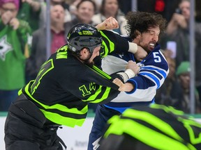 Dallas Stars left wing Jamie Benn (14) fights with Winnipeg Jets defenceman Brenden Dillon (5) during the second period at the American Airlines Center in Dallas on Feb. 11, 2022.