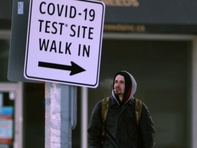 A person walks past a sign for a Covid-19 test site in Winnipeg.