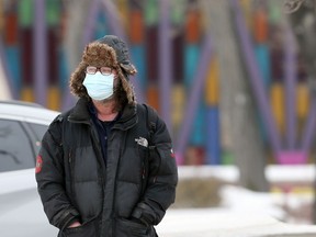 A man wearing a mask at Osborne Junction in Winnipeg on Monday, Jan. 31, 2022.