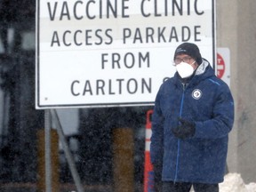 A man wearing a mask passes a sign for the COVID-19 testing site at RBC Convention Centre in Winnipeg on Tues., Feb. 1, 2022.  KEVIN KING/Winnipeg Sun/Postmedia Network