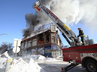 Firefighters work to reposition an aerial ladder truck as fire rips through a historic building at the northwest corner of Langside Street and Portage Avenue in Winnipeg on Wed., Feb. 2, 2022.  KEVIN KING/Winnipeg Sun/Postmedia Network