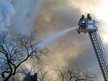 Firefighters on an aerial ladder truck work to contain a blaze in a historic building at the northwest corner of Langside Street and Portage Avenue in Winnipeg on Wed., Feb. 2, 2022.  KEVIN KING/Winnipeg Sun/Postmedia Network