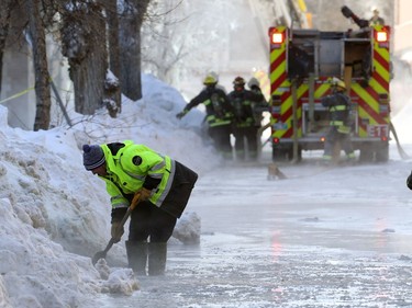 City workers try to improve drainage as firefighters battle a blaze in a historic building at the northwest corner of Langside Street and Portage Avenue in Winnipeg on Wed., Feb. 2, 2022.  KEVIN KING/Winnipeg Sun/Postmedia Network