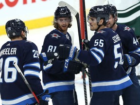 Winnipeg Jets centre Mark Scheifele (55) is congratulated on his power-play goal against the Minnesota Wild in Winnipeg by Blake Wheeler, Kyle Connor and Josh Morrissey (from left) on Tuesday, Feb. 8, 2022.