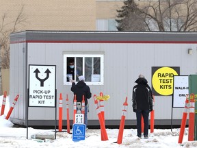An employee uses tongs to hand over a rapid antigen test  at the pickup site on Taylor Avenue in Winnipeg on Wed., Feb. 9, 2022.  KEVIN KING/Winnipeg Sun/Postmedia Network