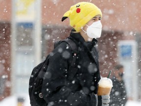A person wearing a mask walking in downtown Winnipeg on Tuesday, Feb. 15, 2022.