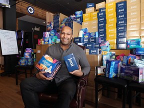 Owner Ravi Ramberran holds tampons and pads for donation to high school and women's shelters at the Four Crowns Restaurant in Winnipeg on Monday, Feb. 21, 2022. Ramberran also owns St. James Burger & Chip Co., and said that between the two eateries they have collected more than $30,000 worth of menstrual products.