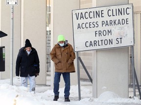 People walk around a sign for the COVID-19 vaccination site at RBC Convention Centre in Winnipeg on Tues., Feb. 22, 2022. KEVIN KING/Winnipeg Sun/Postmedia Network