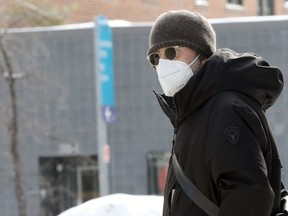 A man wearing a mask on Broadway in Winnipeg on Monday, Feb. 28, 2022.