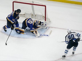 Winnipeg Jets' Pierre-Luc Dubois (80) scores the game-winning goal past St. Louis Blues' Colton Parayko (55) and goaltender Jordan Binnington (50) during overtime of an NHL hockey game Sunday, March 13, 2022, in St. Louis.