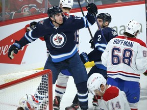 Winnipeg Jets centre Adam Lowry (left) celebrates his gaol against the Montreal Canadiens in Winnipeg with Dylan DeMelo on Tuesday, March 1, 2022.
