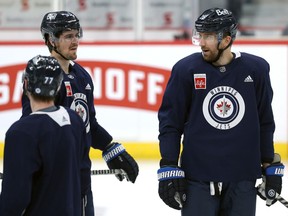 Winnipeg Jets captain Blake Wheeler (right) and linemate Mark Scheifele chat during practice on Monday, March 7, 2022.